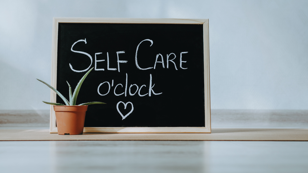 Self care 0´clock chalkboard with heart and behind small aloe plant.
